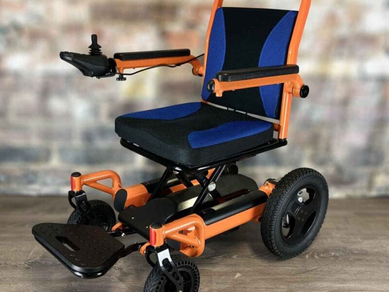 An orange and blue wheel chair sitting on a wooden floor.